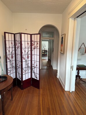 A hallway with wooden flooring, a traditional Japanese shoji screen, and a bookshelf in the background. - Historic Court Square Walkable 2-bedroom Condo in Downtown Charlottesville (Charlottesville)