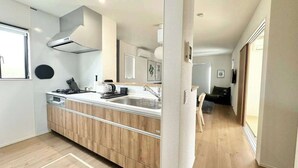 A modern kitchen with a central island, built-in oven, and stainless steel appliances.