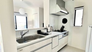 A modern kitchen with a double sink, stainless steel appliances, and a large window. - 10 mins to kumamoto airport Spacious 4BR House by Restavio (Ozu)