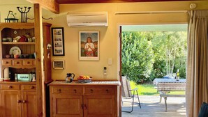 Una camera accogliente con mobili in legno, un tavolo da pranzo con vista sull'esterno e un'ampia finestra con tende.