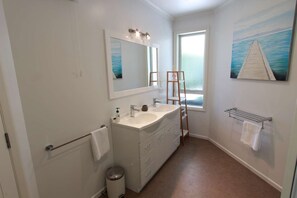 A modern bathroom with two sinks, a large mirror, a towel rack, and a window with a view of the sea. - Patons Rock Latitude - Modern Getaway (Patons Rock)