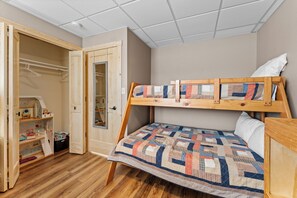 A compact bedroom with a bunk bed, wooden closet, and a small storage unit. - Game Room Log Cabin Near Dells Hot Tub (Lyndon Station)