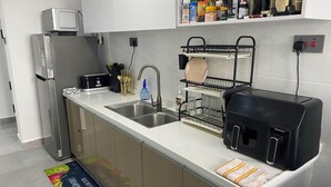 A modern kitchen with stainless steel appliances, a dish rack, and a variety of kitchen utensils. - Lovely 2-bedroom in Nairobi near Yaya Centre — Everything Walkable (Nairobi)
