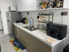 Eine moderne Küche mit Edelstahlgeräten, einem Geschirrgestell und verschiedenen Küchenutensilien.