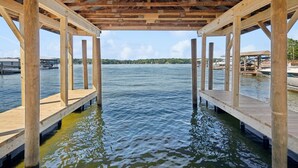 A wooden pier structure with a view of a calm lake and distant shoreline. - Tranquility on the Lake (Lake Norman of Catawba)