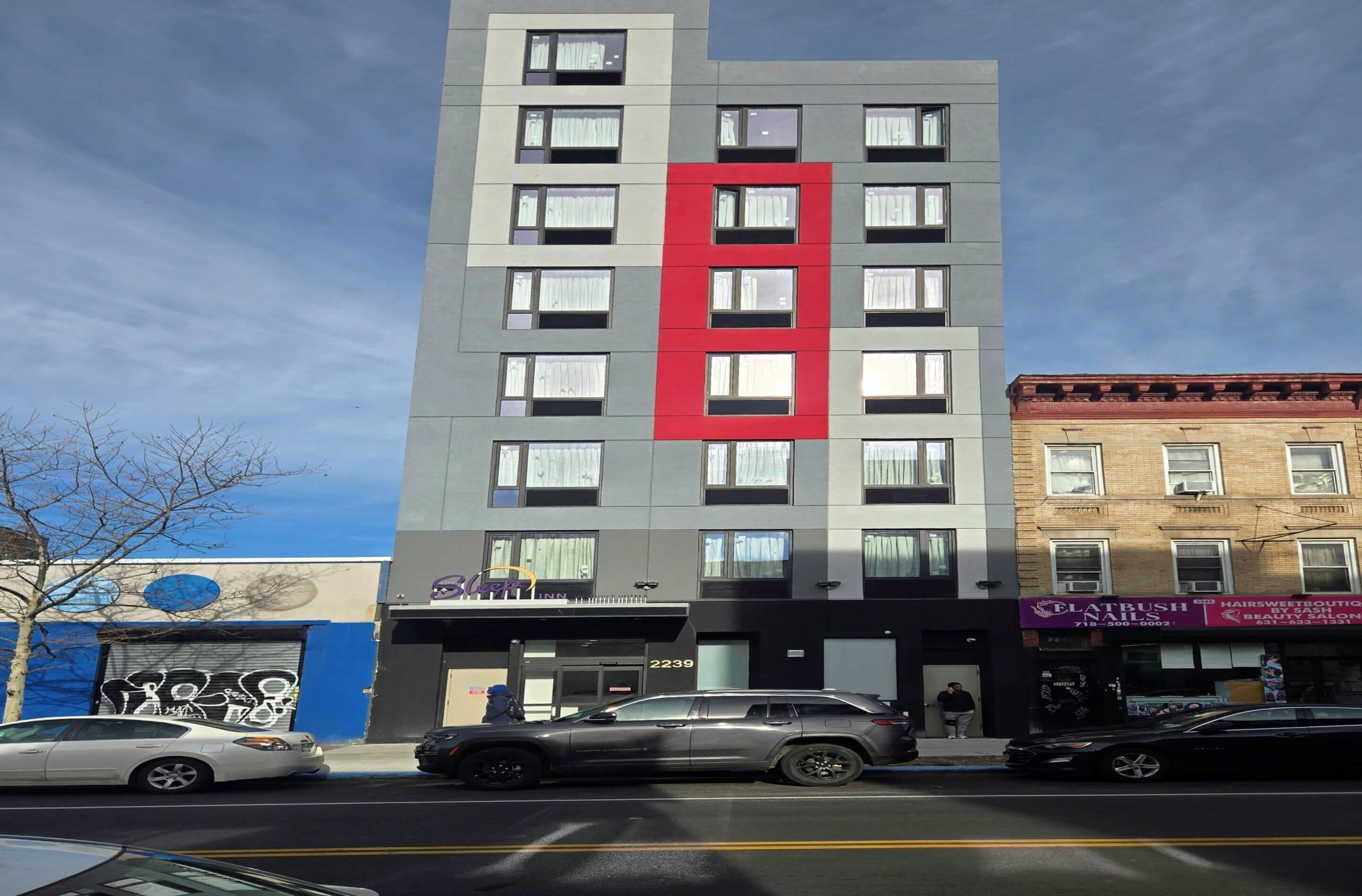 A multi-story building with a prominent red vertical stripe on the facade.