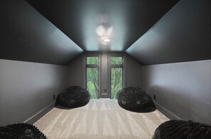 Dark walls, comfortable seating, and a large screen create an immersive movie-night escape. - Lake Norman Estate • Hot Tub + Fire Pit + Movie Theater | Lion Manor (Denver)