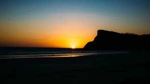 A beach at sunset with a cliff on the right. - Town House 4: Comfort and golf course view (Hacienda Iguana)