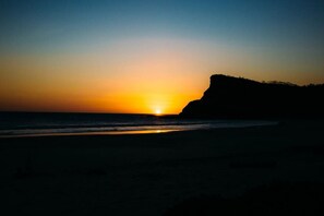 A beach at sunset with a cliff on the right. - Town House 4: Comfort and golf course view (Hacienda Iguana)
