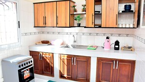 A kitchen with wooden cabinets, a Westpak oven, a sink, and a countertop with various items. - MAGNIFICENT FURNISHED VILLA, TEMPORARY RENTAL, CITE ALiou Sow Golf Sud (Dakar)