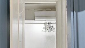 Una stanza con una porta bianca, un pavimento di legno e un piccolo oggetto nero sul pavimento.
