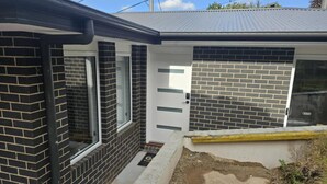 A modern house with a brick exterior, a white door, and a garage door.