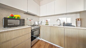 Une cuisine moderne équipée d’un four à micro-ondes, d’une cuisinière et d’un évier.