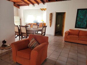 A living room with a sofa, a dining area with a table and chairs, and a kitchen in the background. - Spacious house located in Vieux Fort, few minutes from Hewanorra Airport (Vieux Fort)