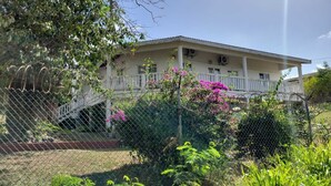 A two-story building with a covered porch and a staircase leading to the entrance. - Spacious house located in Vieux Fort, few minutes from Hewanorra Airport (Vieux Fort)