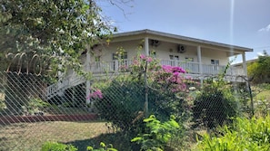 A two-story building with a covered porch and a staircase leading to the entrance. - Spacious house located in Vieux Fort, few minutes from Hewanorra Airport (Vieux Fort)