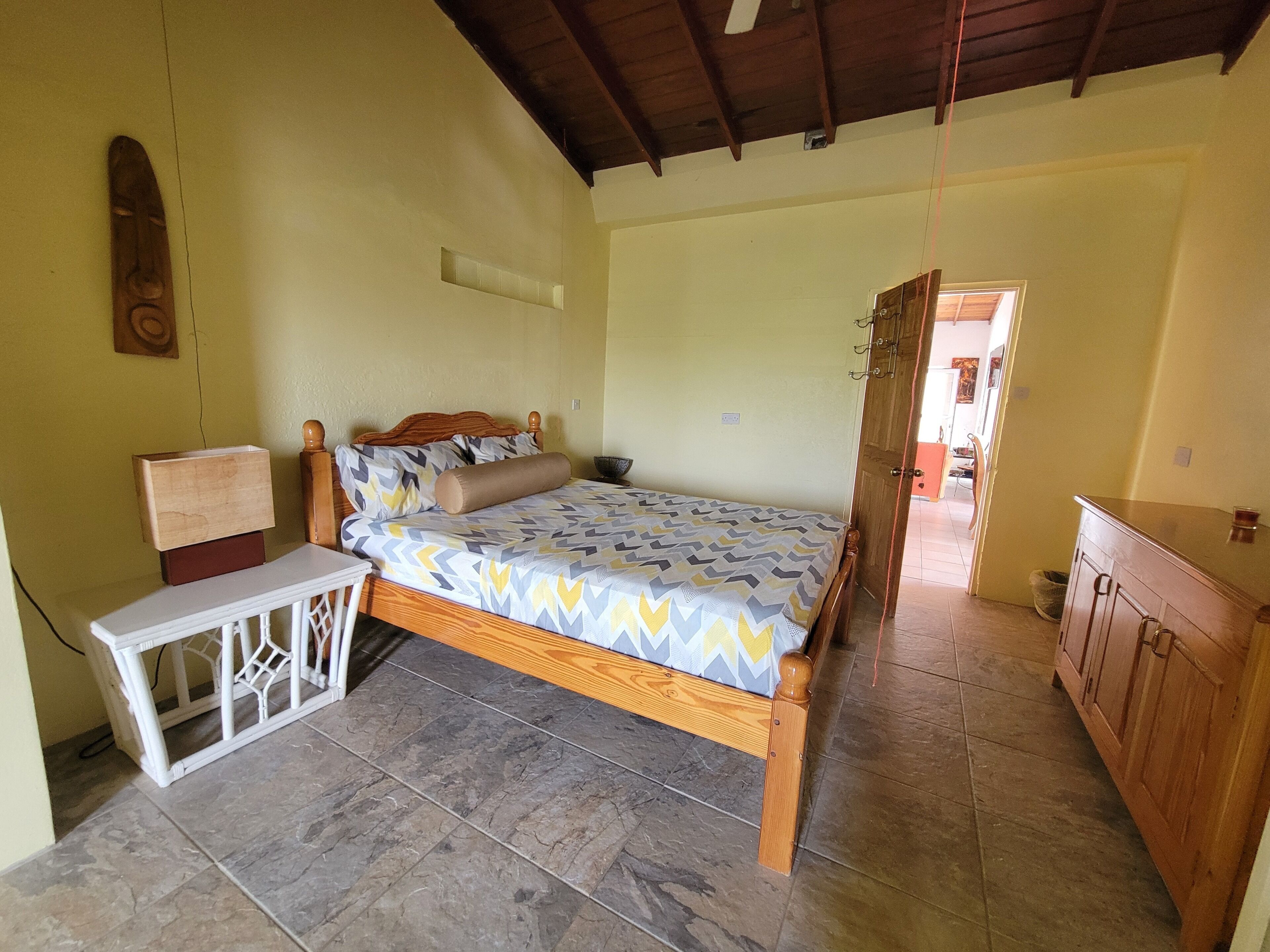 Une chambre à coucher avec un lit, une table de chevet et une armoire en bois.