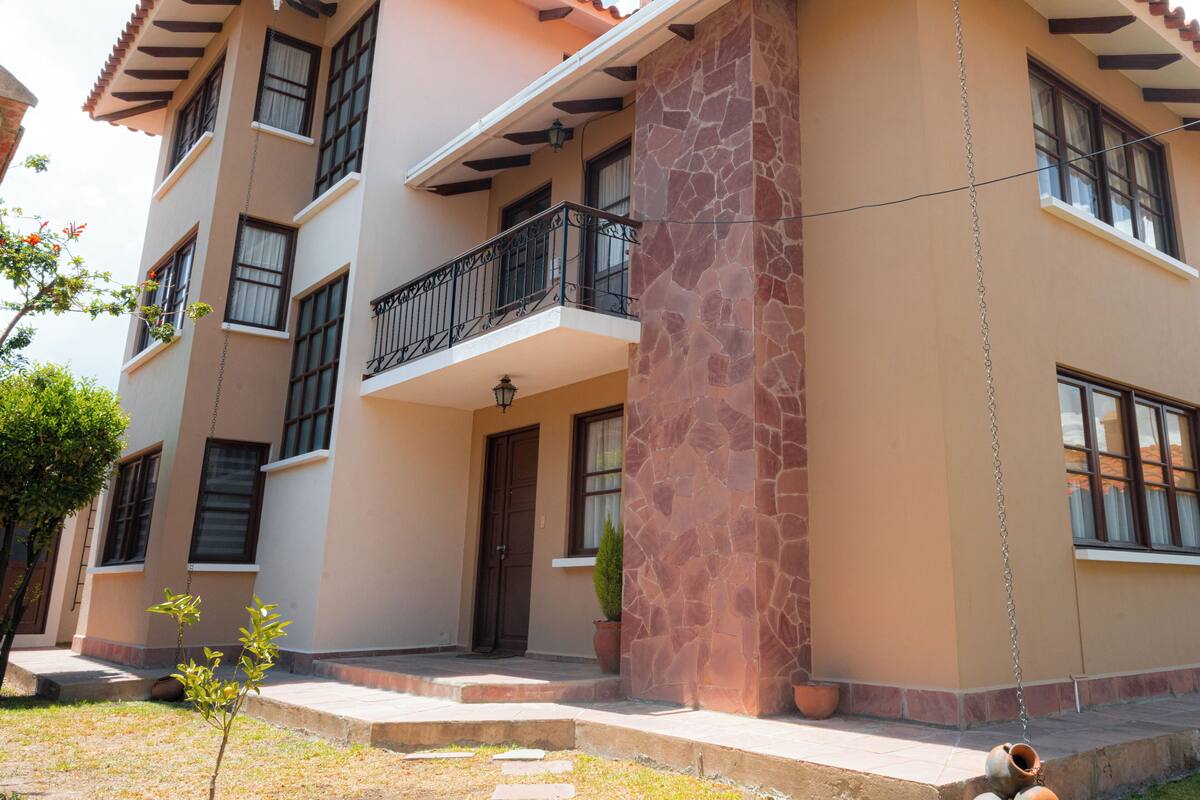 A multi-story building with a balcony, a stone column, and a door.