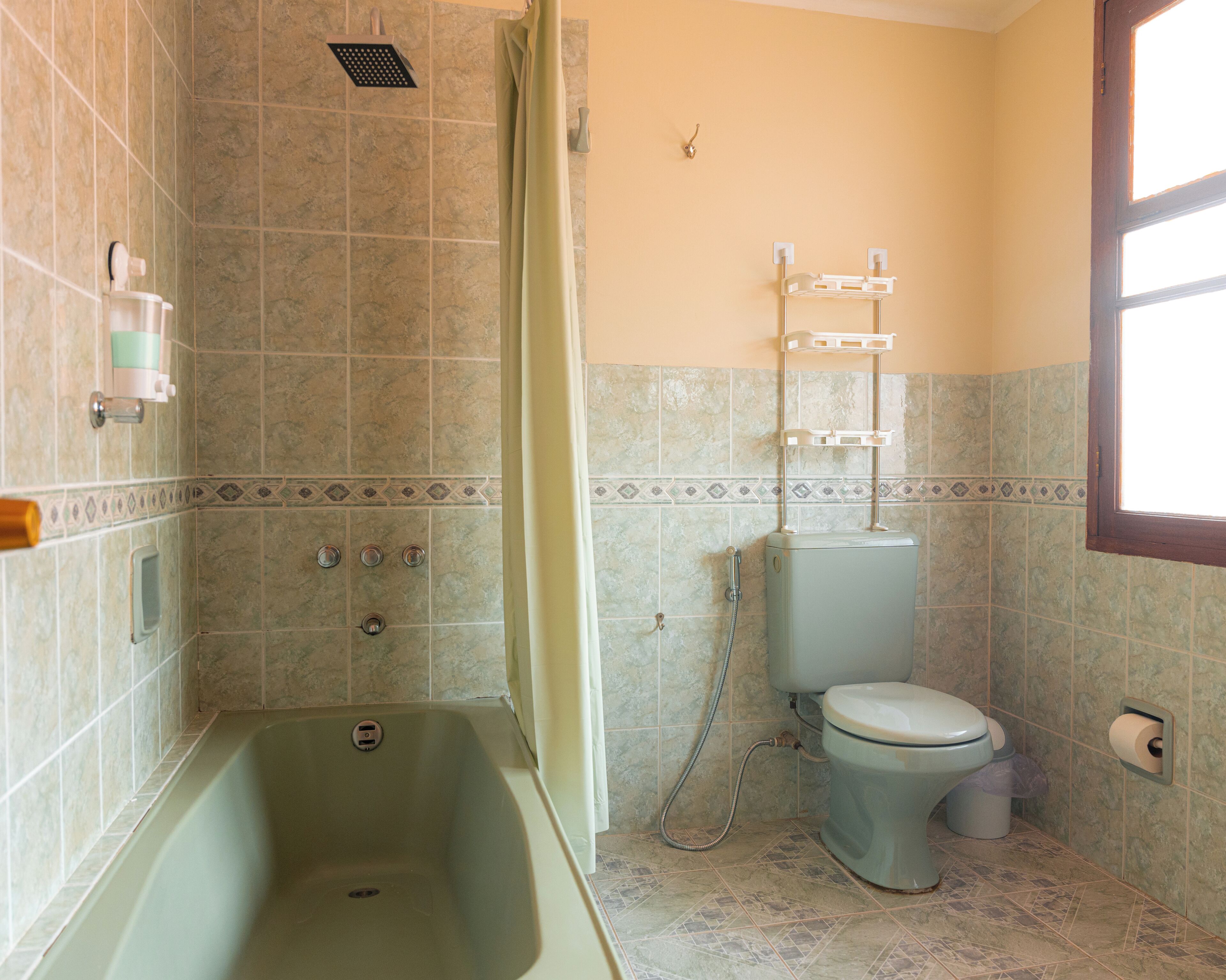 A bathroom with a bathtub, toilet, and shower.