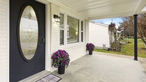 A house with a black front door, white siding, and a covered porch. - Stylish 3BR, 2BA 8m Away Expo Hub, 12m from Down Town Louisville, 12M from Derby (Louisville)
