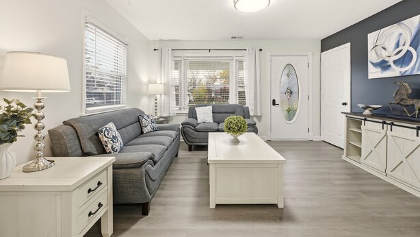 A modern living room with two grey sofas, a white coffee table, and a white cabinet with a decorative item on top. - Stylish 3BR, 2BA 8m Away Expo Hub, 12m from Down Town Louisville, 12M from Derby (Louisville)