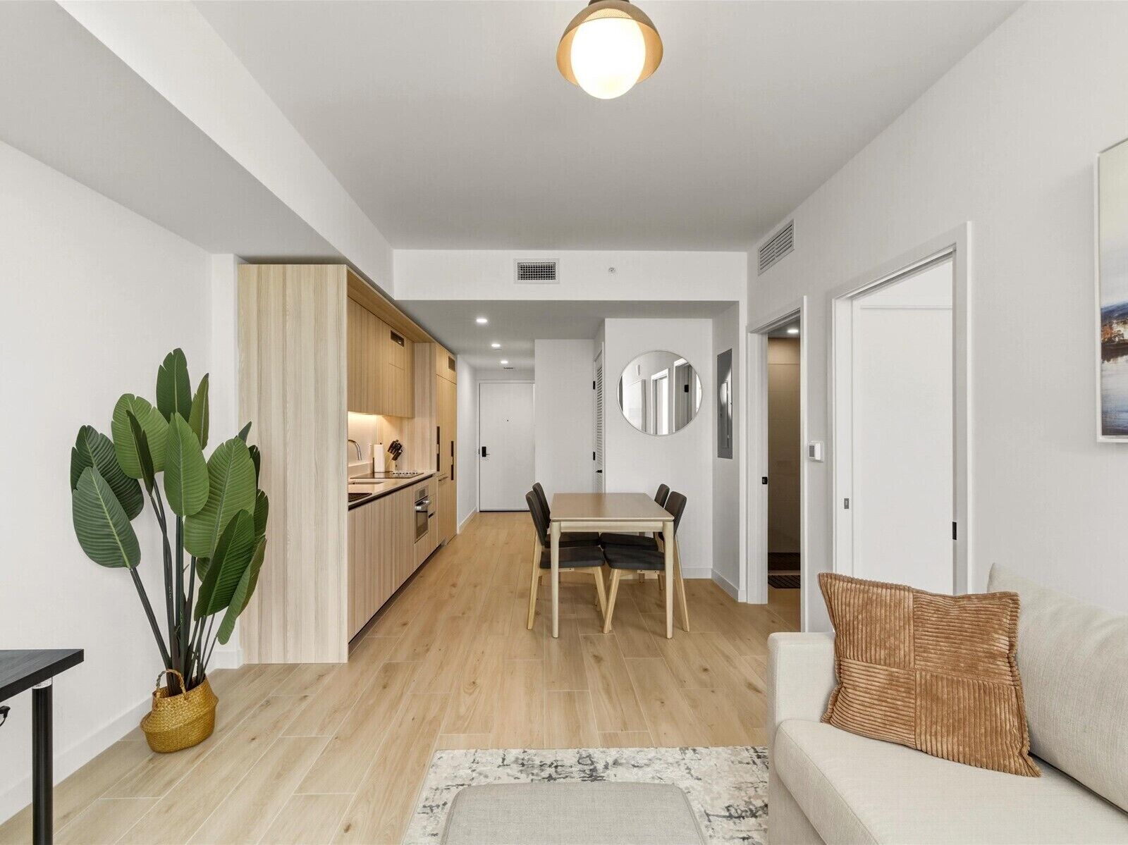 A modern apartment with a kitchen, dining area, and living room.
