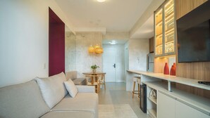 A modern kitchen with a TV, wooden cabinets, and a dining area with a table and chairs. -  Fully Equipped Apartments 220 m From the Beach in Jurerê Rtys (Florianópolis)