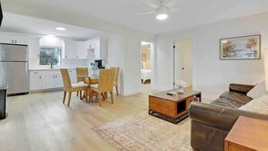 A modern apartment with a kitchen, dining area, and living room. - Cottage on California (Stuart)