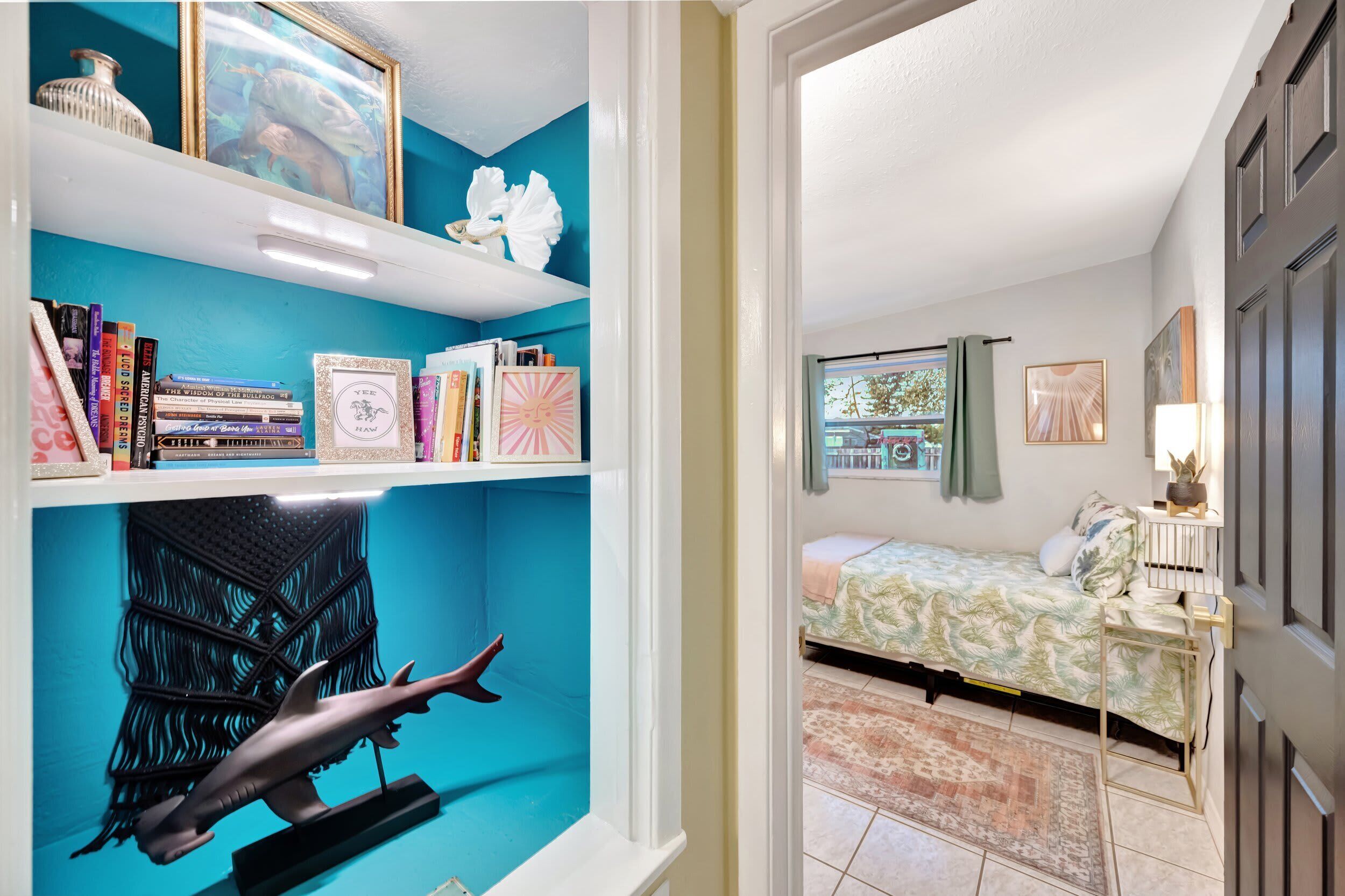 A bedroom with a bed, a window, and a view of the outside.