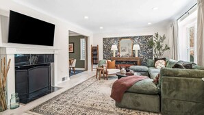 Una sala de estar con chimenea, sofá y televisor.
