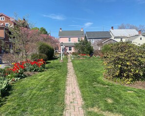 Un quartier résidentiel avec un chemin pavé menant à une maison dont la porte est rouge.