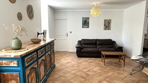 A living room with a brown leather sofa, a wooden coffee table, and a black metal chair. There is a white door and a wall with decorative plates. - LACROUTZ - SAINT MARTIN DE SEIGNANX (SAINT MARTIN DE SEIGNANX)