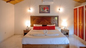 Un dormitorio ordenado con una cama grande, dos mesitas de noche, un cabecero y un aire acondicionado instalado en la pared.
