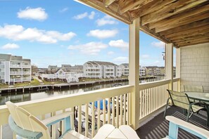 Un balcon avec vue sur un port de plaisance et des immeubles d’habitation.