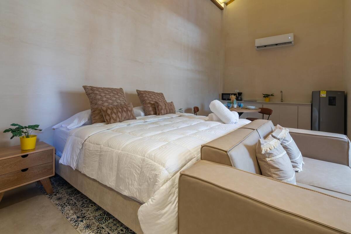 Un dormitorio con cama, mesita de noche y un pequeño escritorio.