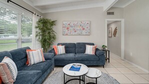 A modern living room with two sofas, a coffee table, and a large window.