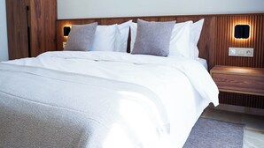 A modern hotel room with a large bed, wooden headboard, and bedside tables with built-in lighting. - Luxury 3 Suites - Av Annakhil - Panoramic View (Rabat)
