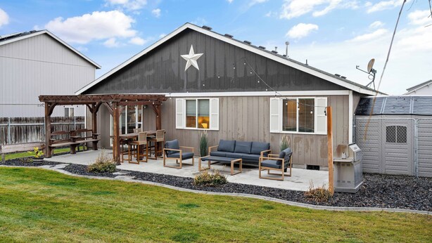 Een huis met een grote ster aan de gevel, een overdekte patio met houten meubels en een schotelantenne.