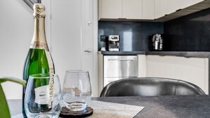 Una ampolla de xampany brut, dues flautes i una taula en un ambient de cuina modern.