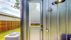 A door with a window, a small balcony, and a wall-mounted light fixture.