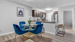 A modern kitchen with dark wooden cabinets, a stainless steel refrigerator, and a white countertop. - Serene Waterfront 2BR  Poolside Living in Fort Lauderdale (Fort Lauderdale)
