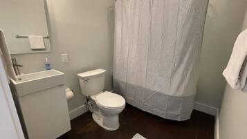 A bathroom with a toilet, sink, and shower curtain.