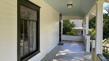 A covered porch with a window and a light fixture.