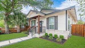 A single-story house with a front porch, a stone foundation, and a well-maintained lawn. - Family Friendly | Patio | Fireplace | BBQ | Games (San Antonio)