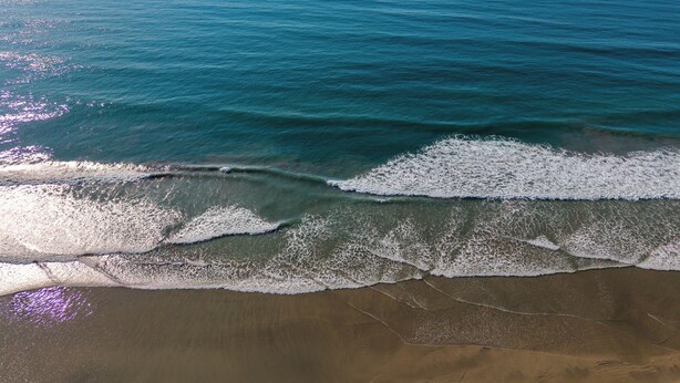 Une plage où les vagues se brisent près du rivage.