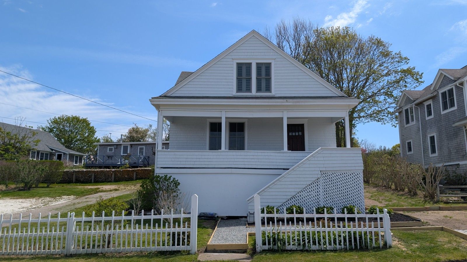A two-story house with a front porch and a white picket fence.