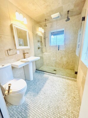 Ein Badezimmer mit Toilette, Waschbecken und Duschbereich.