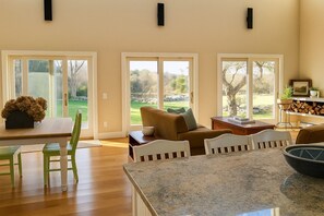 A spacious living area with a dining table, chairs, a sofa, and a kitchen counter. - Blackberry Meadow (New Shoreham)