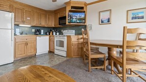 A kitchen with wooden cabinets, a stove, a microwave, and a ceiling fan. - ML238 Breathtaking Mountain View Ski in/out at Ballhooter lift, Next to Village! (Snowshoe)