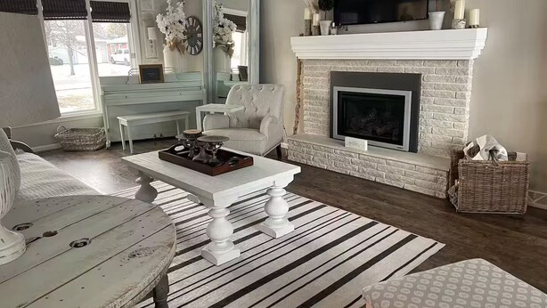 A living room with a fireplace, a television, and a dining area with a table and chairs. - Paisley Dash House (Fargo)